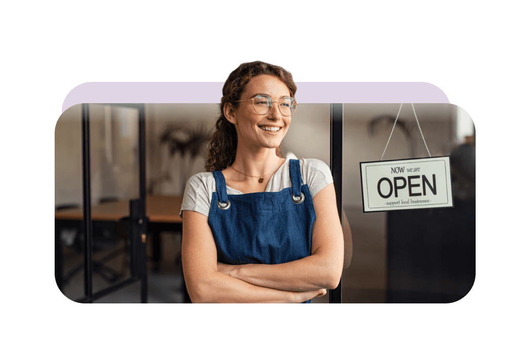 Small business owner standing in the doorway of an open shop, served by Bolt Wireless TELUS business solutions
